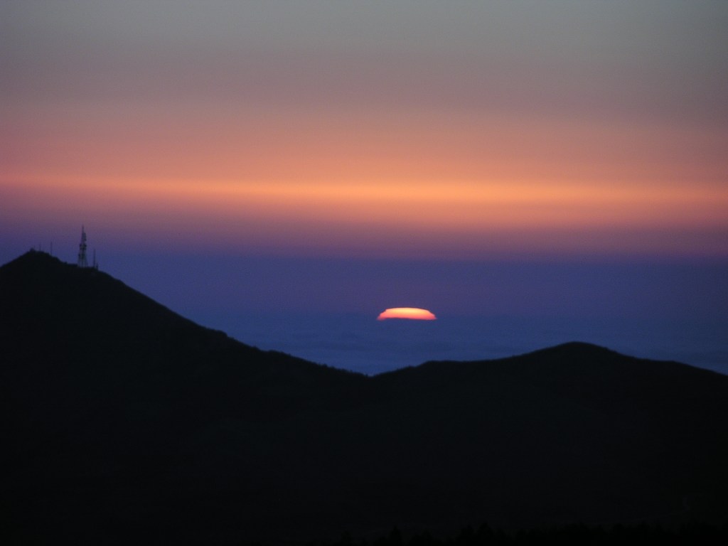 Das erste Sonnenlicht scheint aus der Mitte des Mittelmeeres aufzusteigen. Beobachtet vom Calar Alto, Andalusien, Spanien.