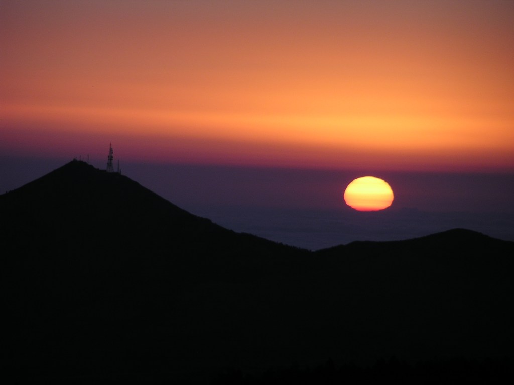 Eine verformte Sonne schwebt über dem Mittelmeer.