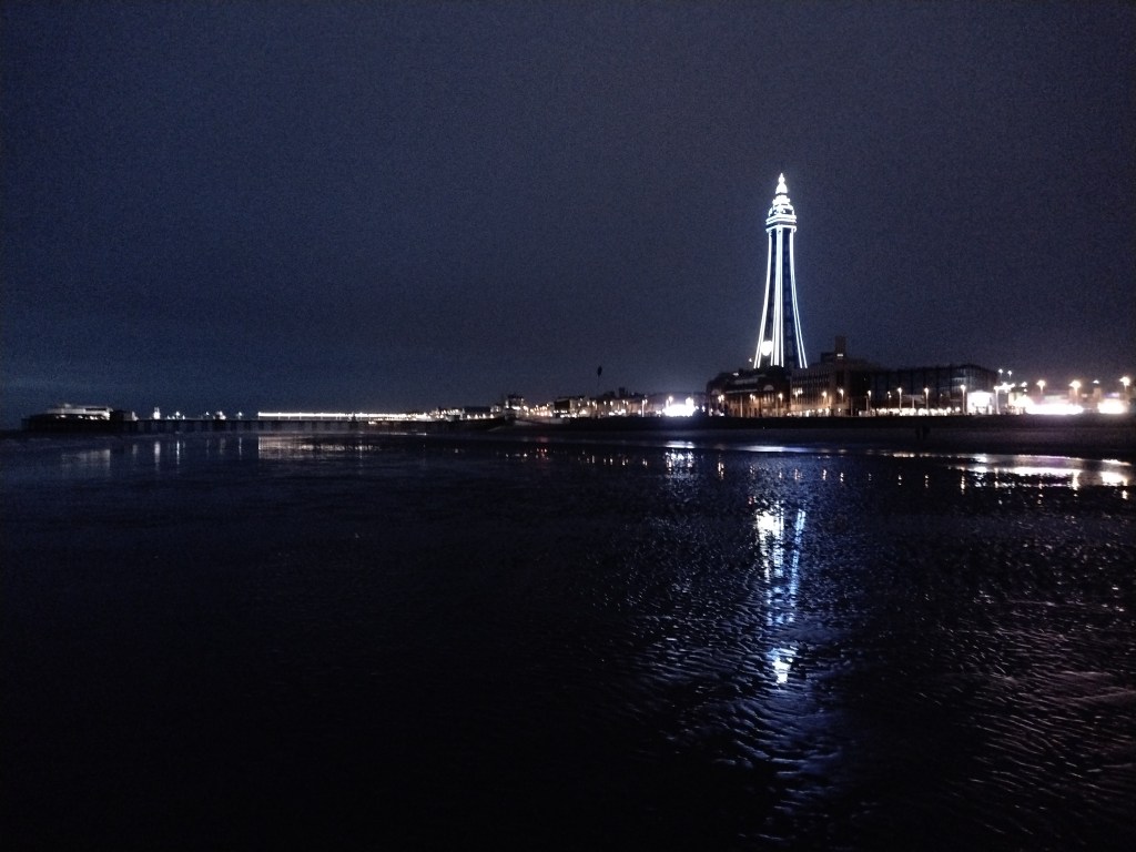 Blackpool tower und Nord-Pier und viel Strand in der Nacht.